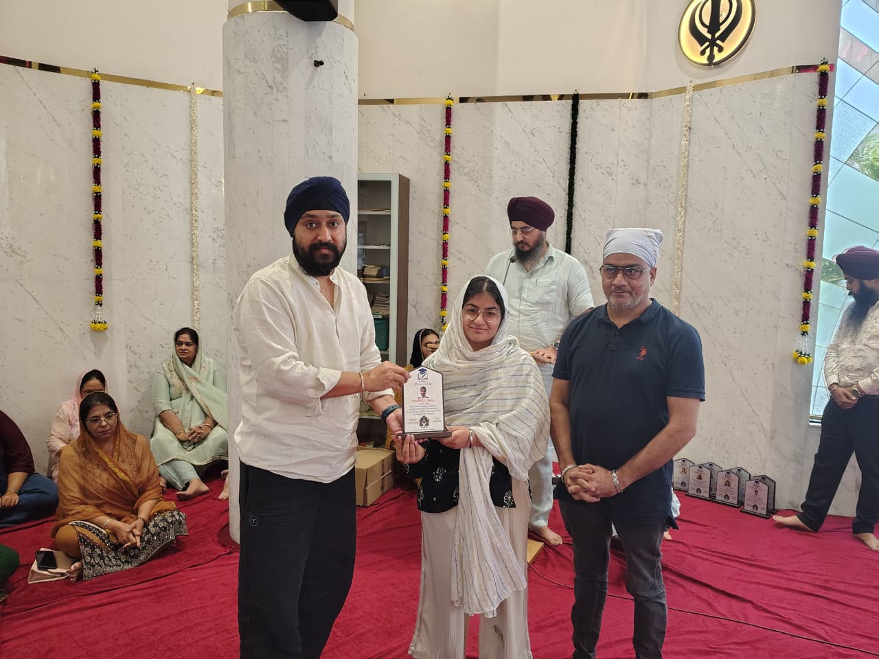 VPCF trustees felicitating a student with a Student Achievement Award plaque
